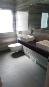 modern bathroom with concrete floor and double vanity, geometric design